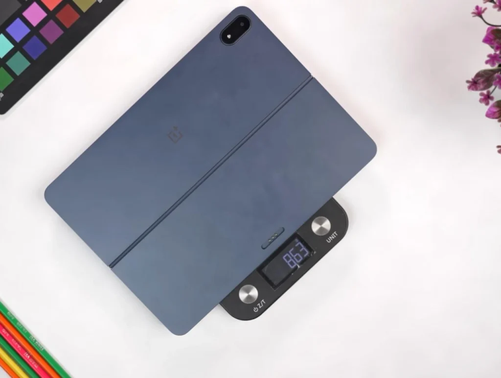 OnePlus Pad 3 Review (After Long Term Test) OnePlus Pad 3 with case viewed from the back on a digital scale